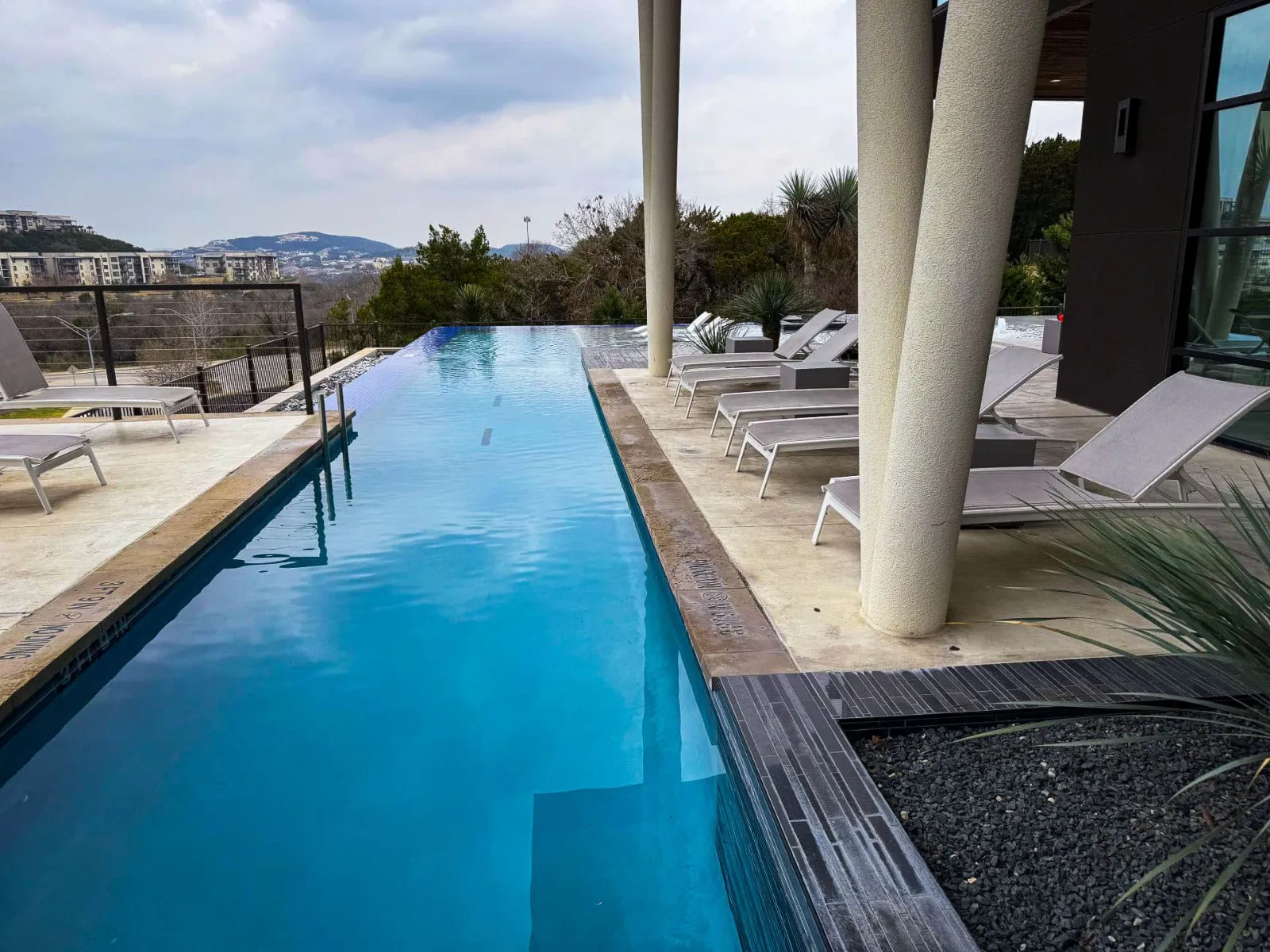 Long modern lap pool beside a covered patio